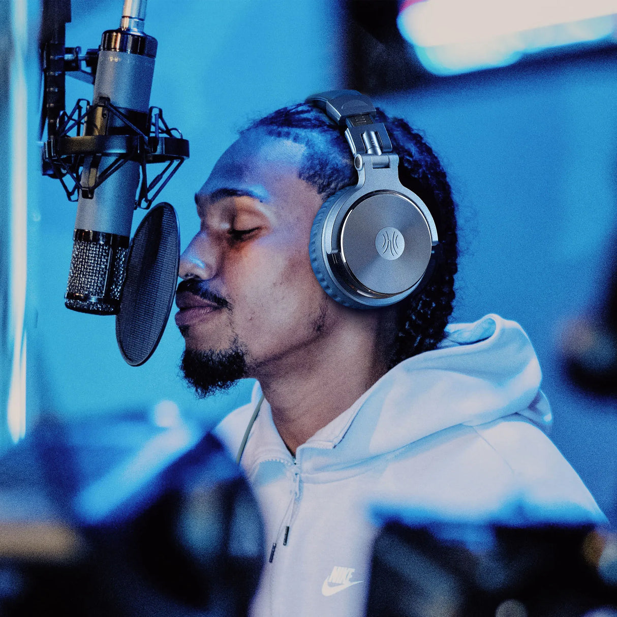 Man singing into microphone with headphones.