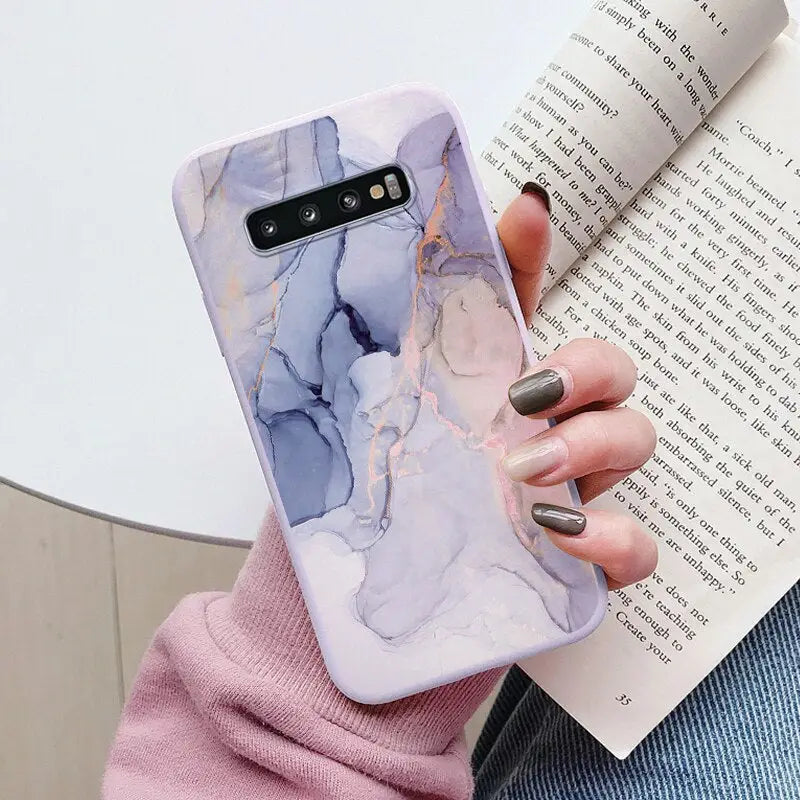 a woman holding a book and a phone case