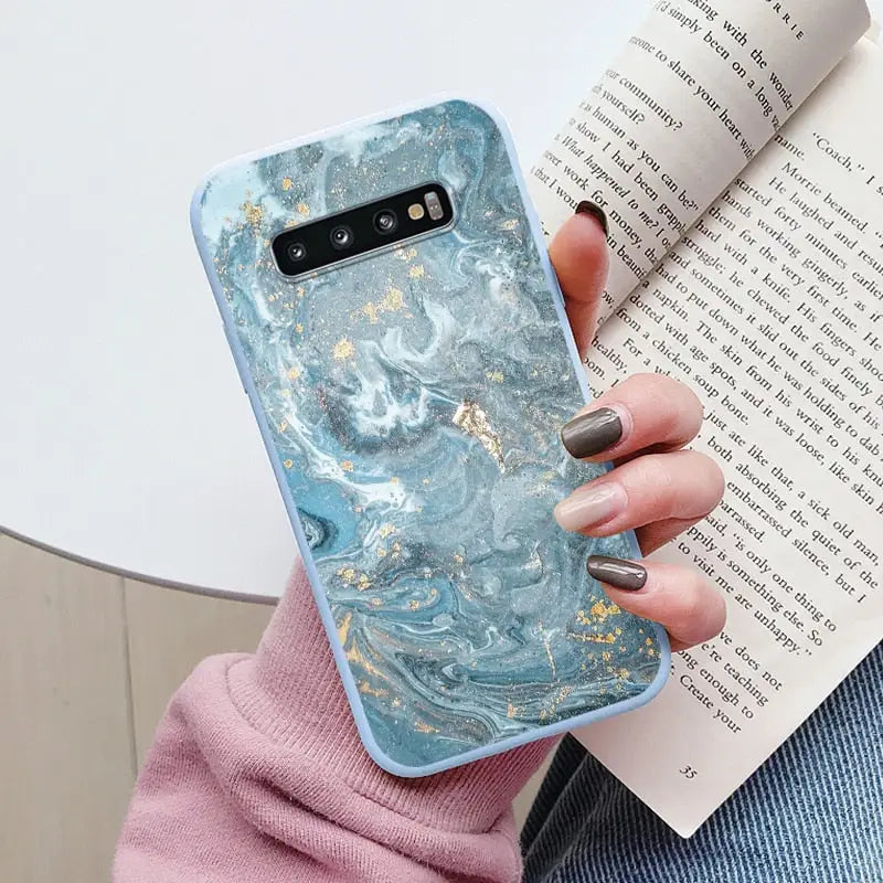 a woman holding a book and a phone case