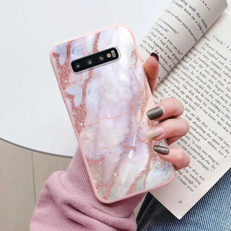 a woman holding a pink marble phone case