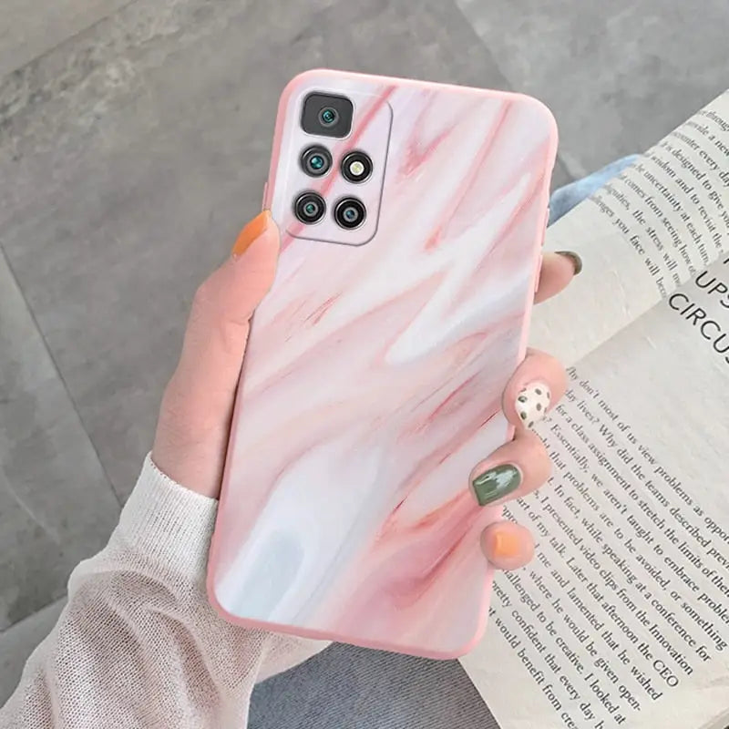 a woman holding a pink marble phone case