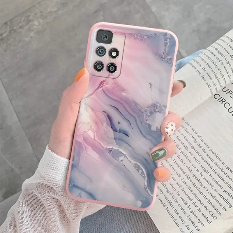 a woman holding a phone case with a marble pattern
