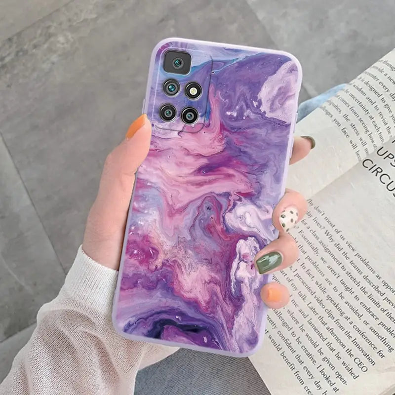 a woman holding a purple marble phone case