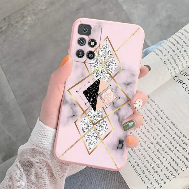 a woman holding a pink marble phone case with gold geometric design