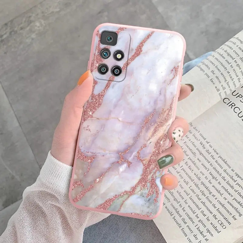a woman holding a pink marble phone case