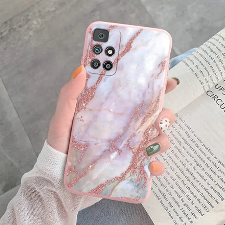 a woman holding a pink marble phone case