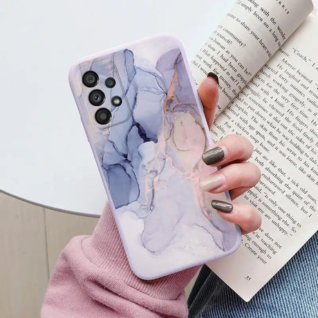 a woman holding a book and a phone case