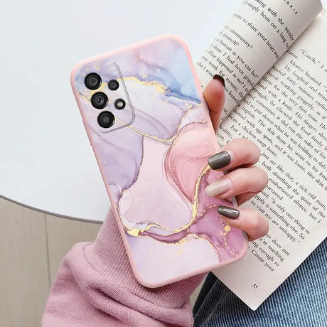 a woman holding a book and holding a phone case