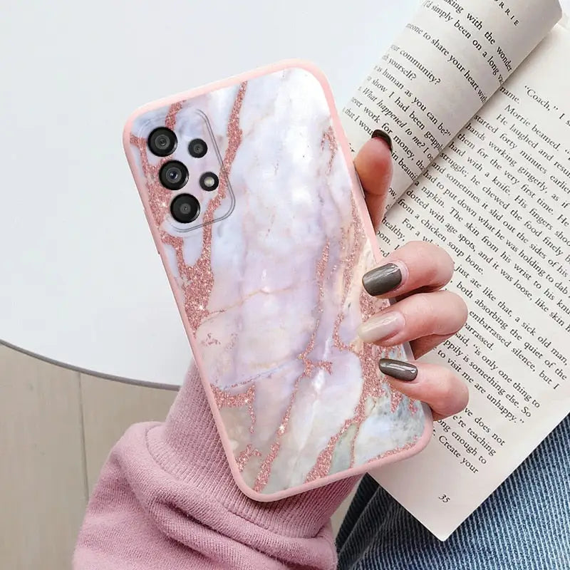 a woman holding a pink marble phone case