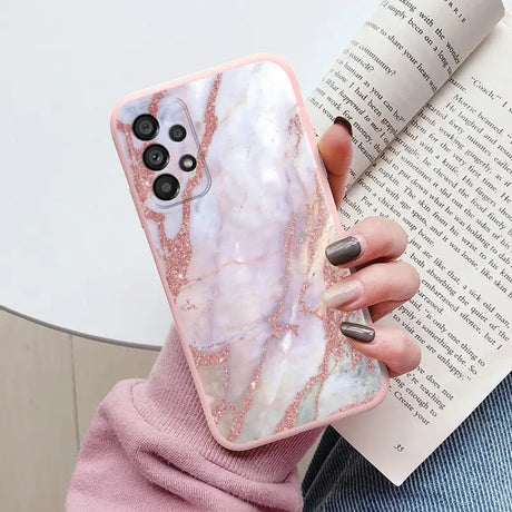 a woman holding a pink marble phone case