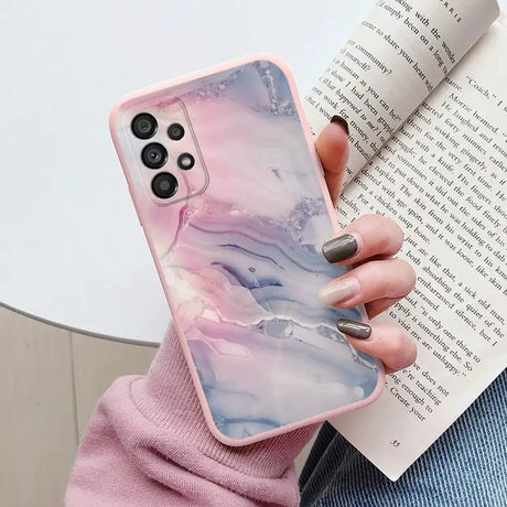 a woman holding a book and a phone case