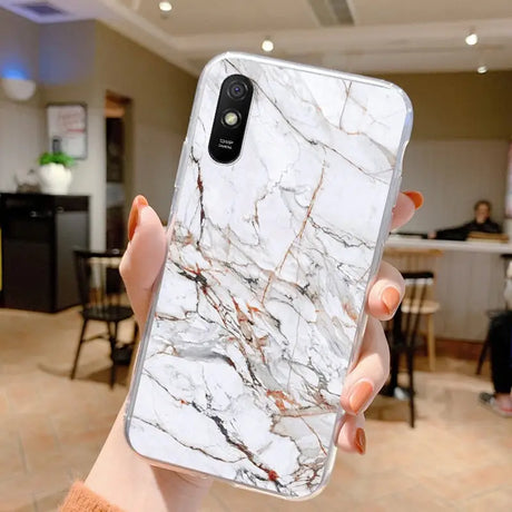 a woman holding a white marble phone case