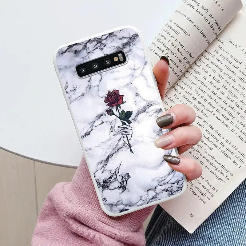 a woman holding a book and a phone case