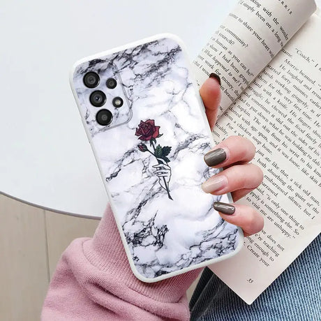 a woman holding a book and a phone case