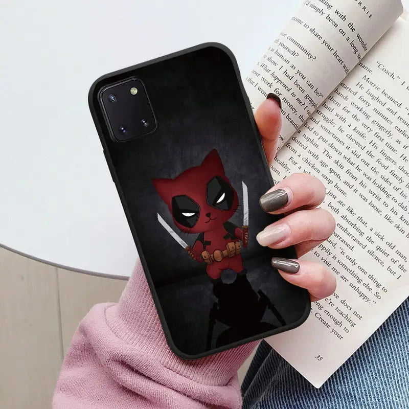 a close up of a person holding a phone case with a deadpool on it