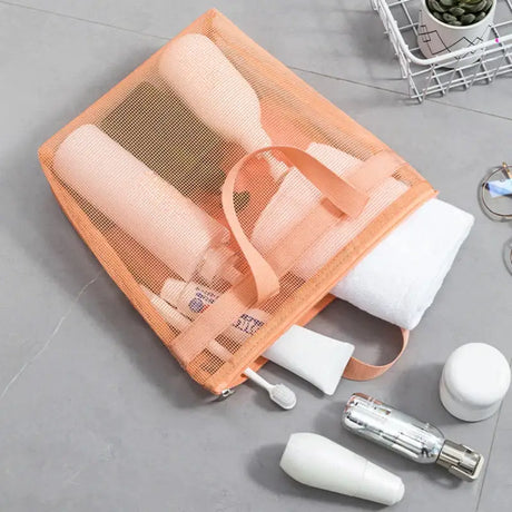 there is a mesh bag with a towel, toothbrushes, and other items