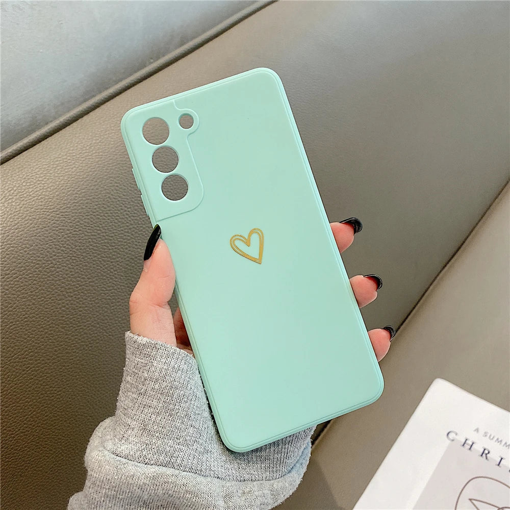 Mint green phone case with a gold heart design.
