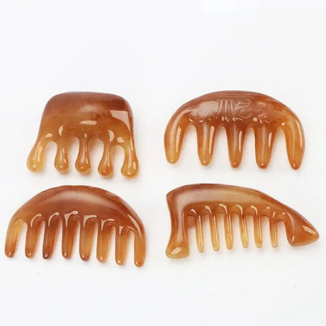 four pieces of brown hair combs sitting on top of a white surface
