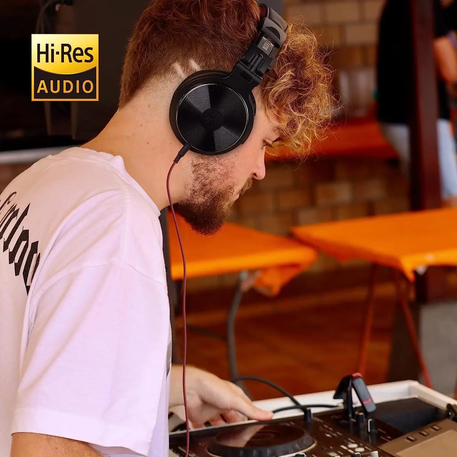 Over-ear headphones worn by a person with curly hair using audio equipment.