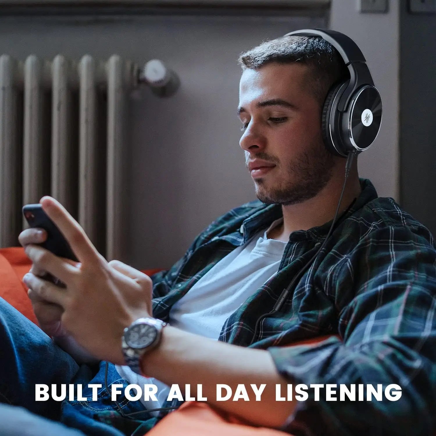 Over-ear headphones worn by a person using a smartphone.