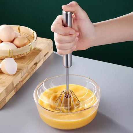 a person is using a beater to beat eggs