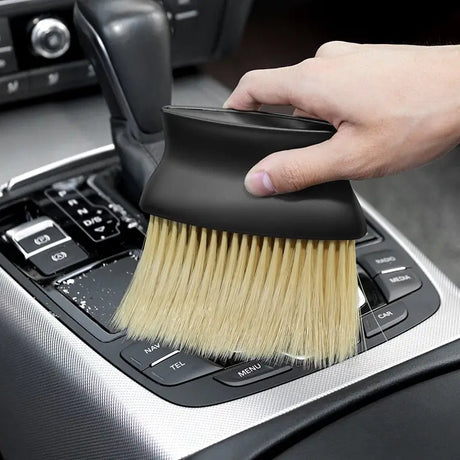 a person cleaning a car with a brush