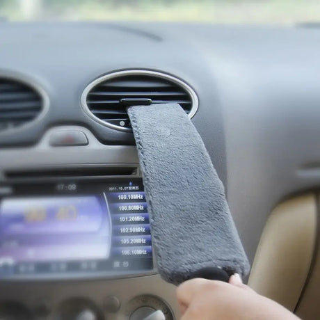 a person is holding a car dashboard with a remote control