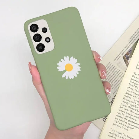 a woman holding a book and a green phone case