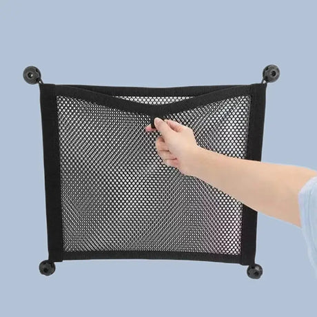 a person holding a mesh bag with a black handle