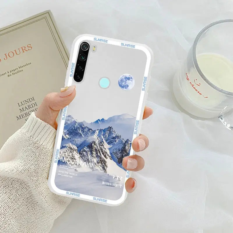 a woman holding a phone case with a mountain scene