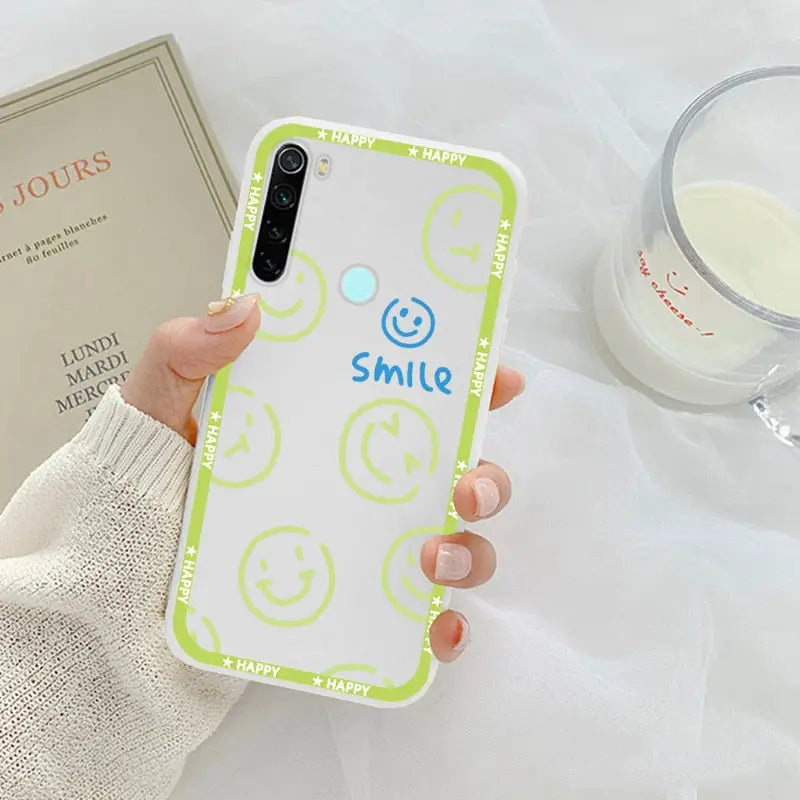 a person holding a phone case with smiley face