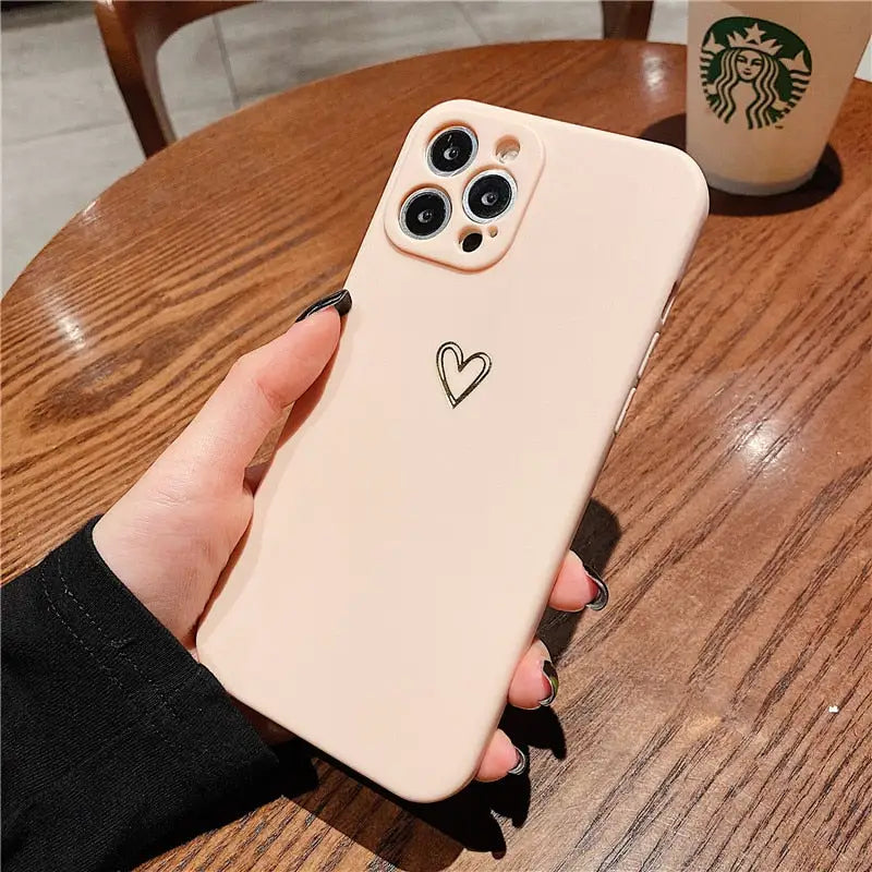a person holding a phone case with a heart on it