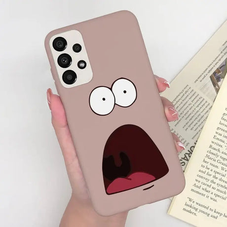 a person holding a phone case with a cartoon face
