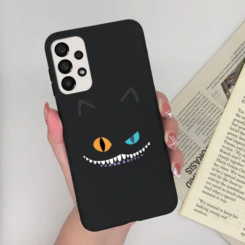 a person holding a phone case with a black cat face
