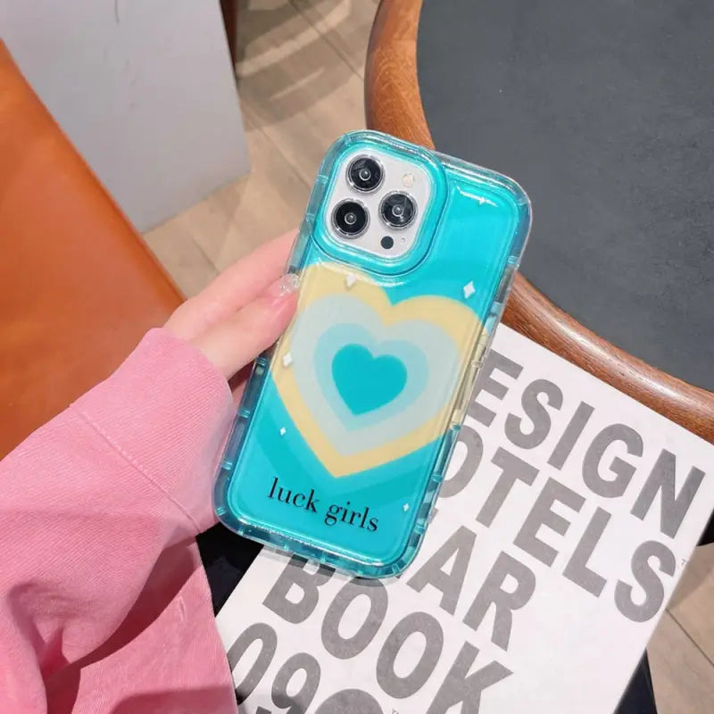 a woman holding a phone case with a heart on it