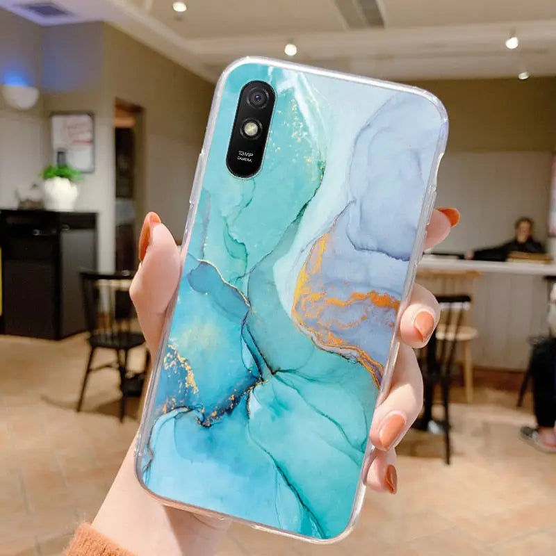 a woman holding up a phone case with a blue marble pattern
