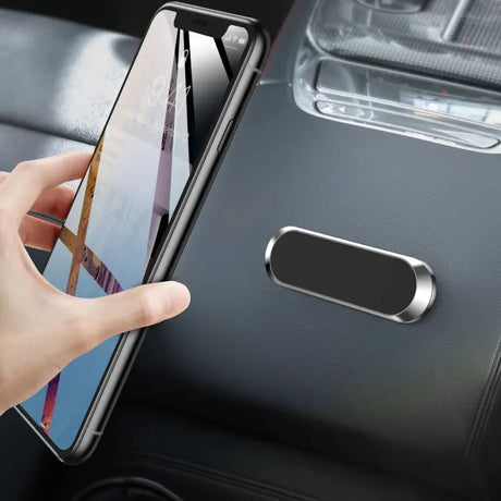 a hand holding a phone in the car