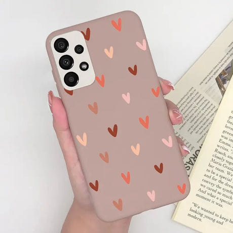 a woman holding a phone case with hearts on it