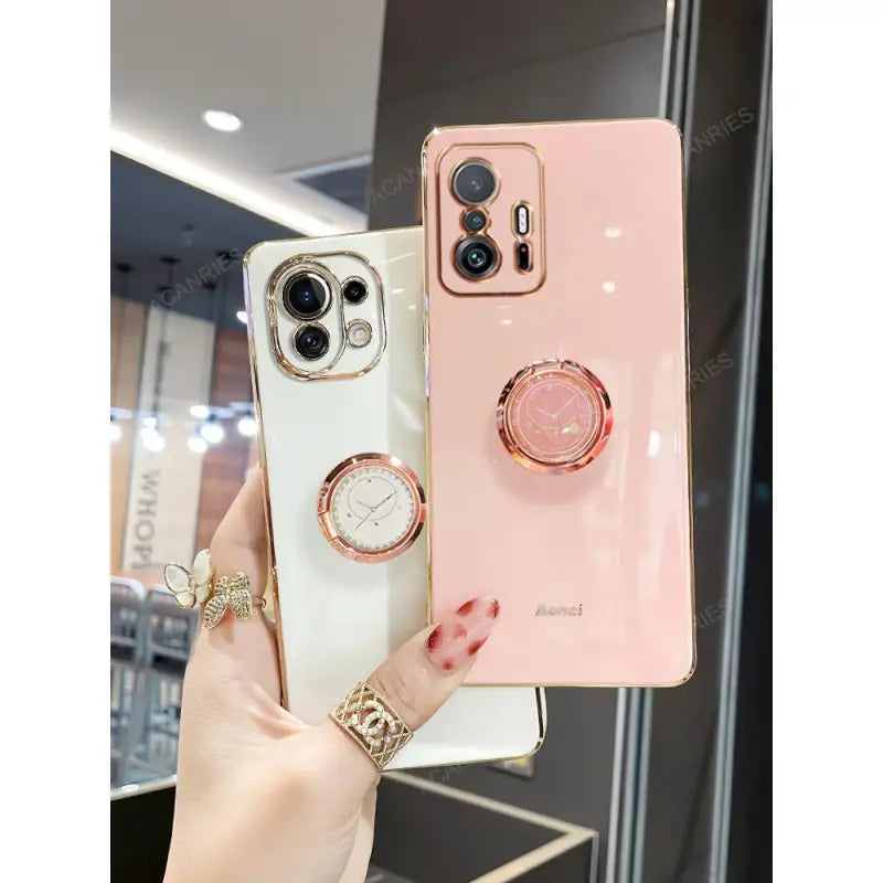 a woman holding a pink iphone case with a watch and ring