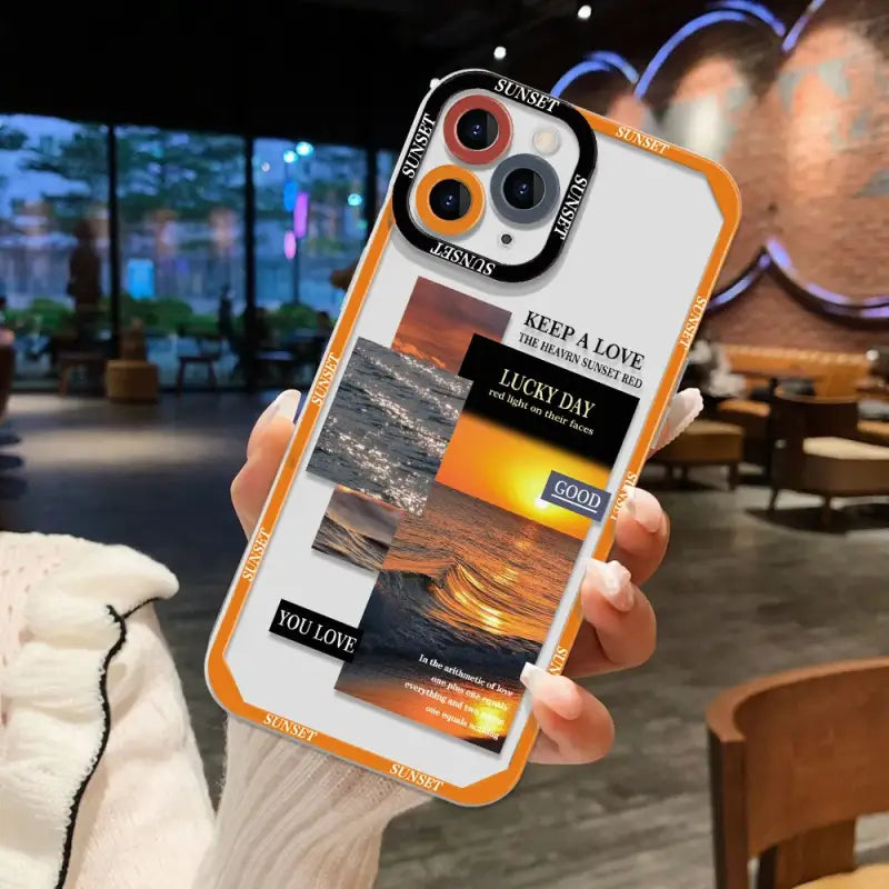 A person holding a phone case with a photo of a sunset