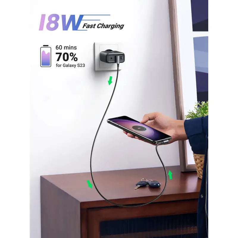 A person holding a phone and charging it