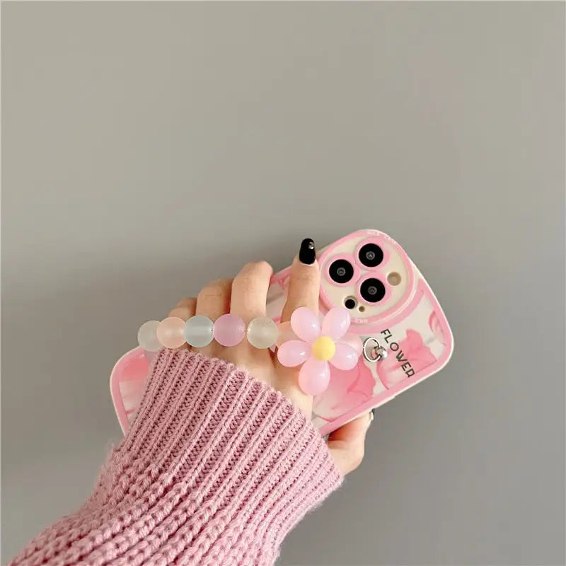 a person holding a pink phone case