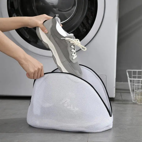 a person is putting a laundry bag into a washing machine
