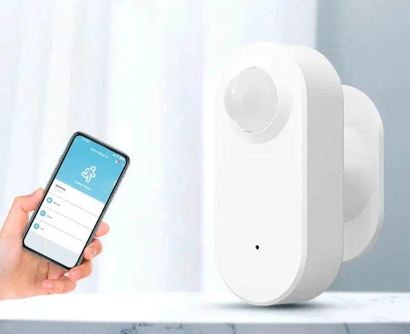 A person holding a smart phone and a smart home security device