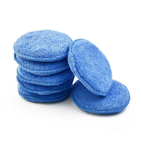 a close up of a pile of blue cloths on a white surface
