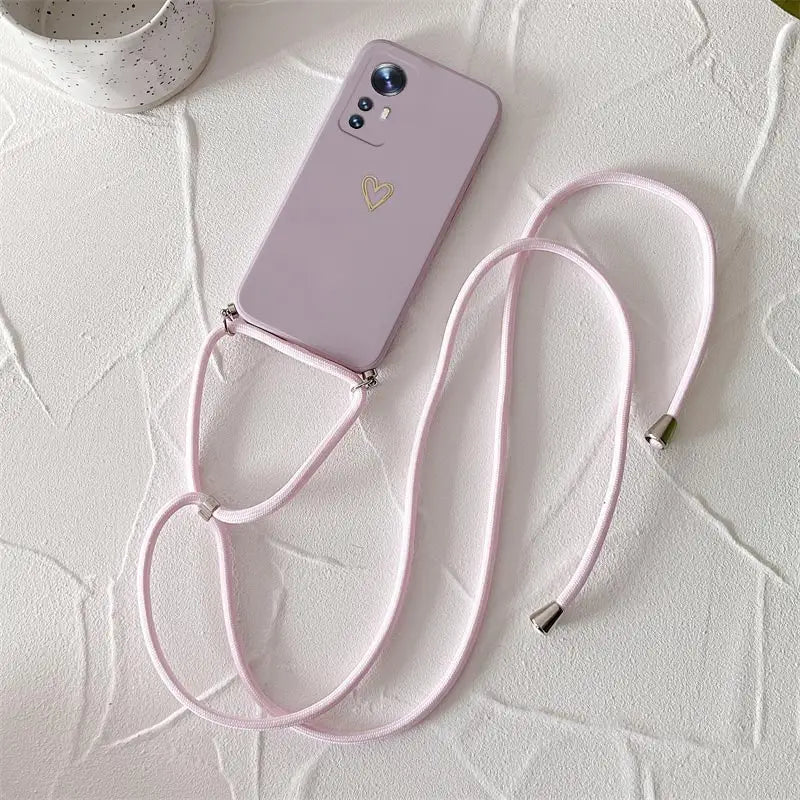 A pink phone case with a pink strap
