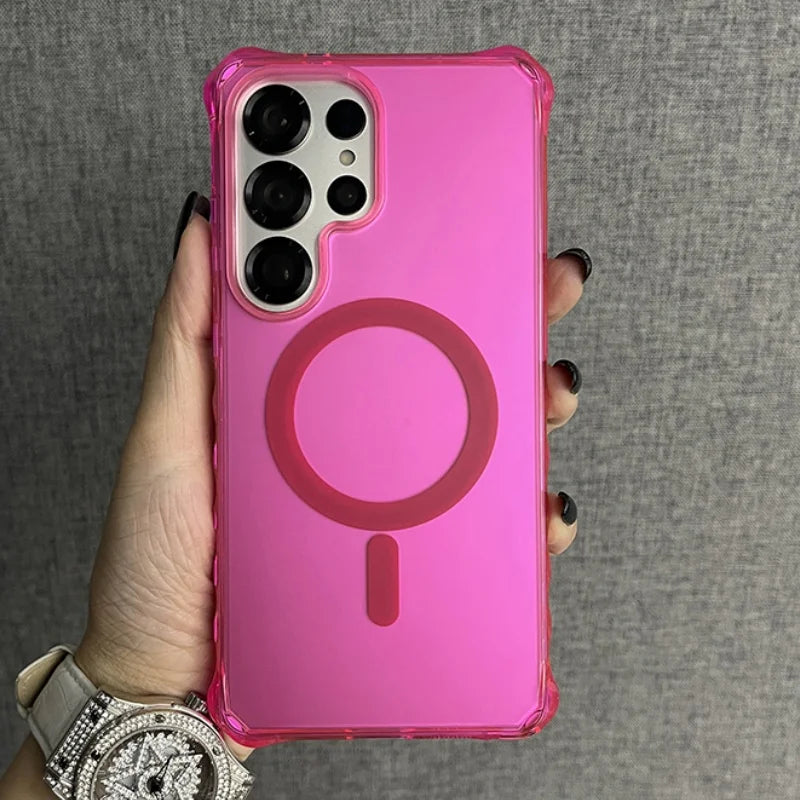 Pink phone case with a transparent back, reinforced corners, and a circular magnetic ring for wireless charging.