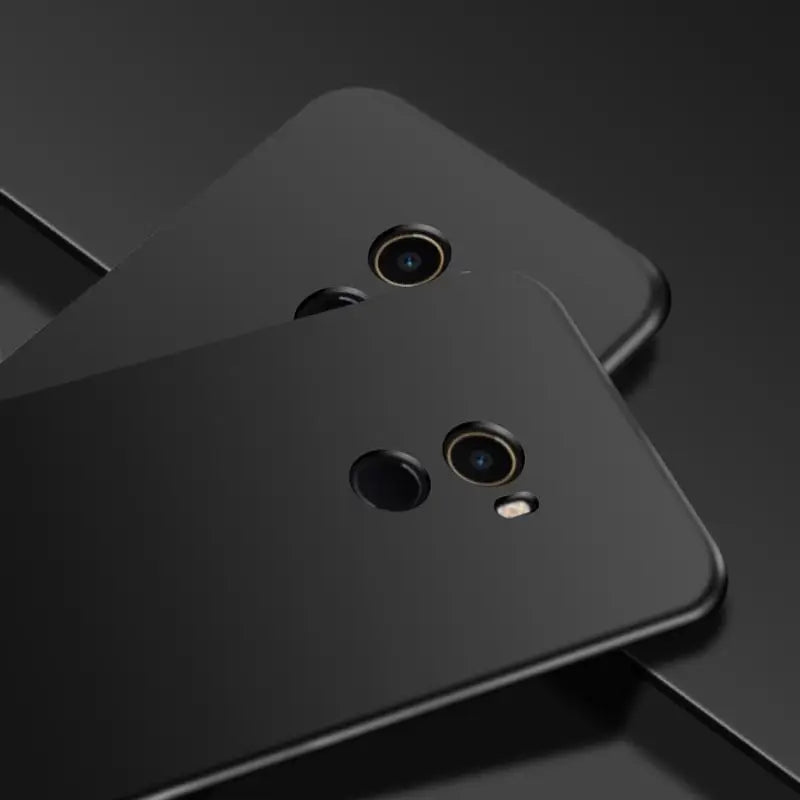 two black smartphones with one facing the camera and one facing the camera