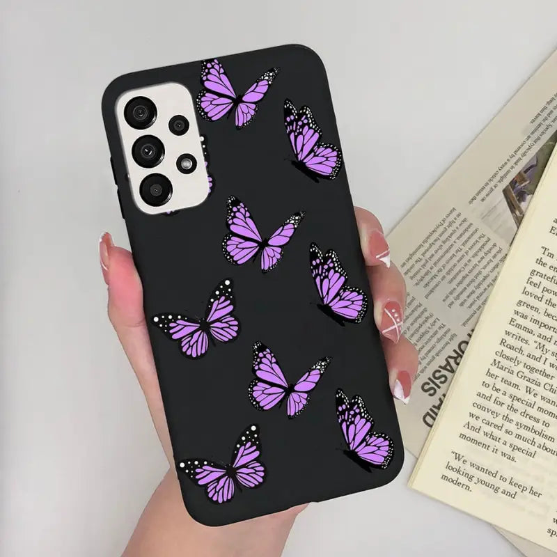 a woman holding a phone case with purple butterflies on it