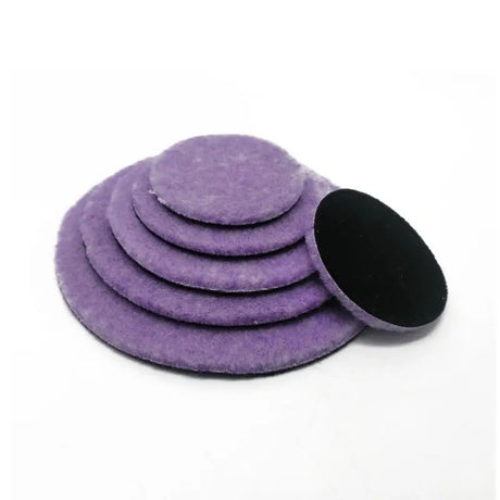 a pile of purple felts with a black circle